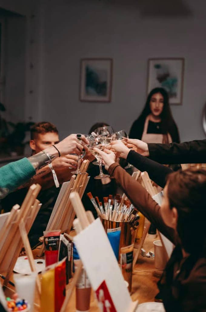Friends raising glasses during a Barcelona painting workshop